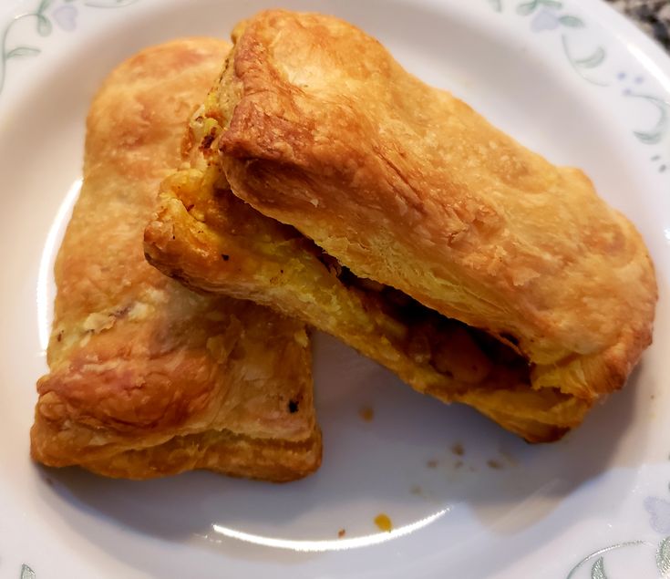 Maruti Live Puff cross-section on a plate showing the spiced filling inside the flaky pastry